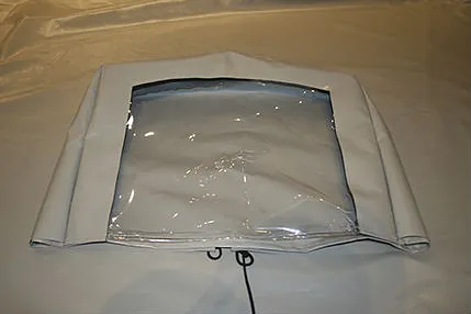 Lys grå duk med gjennomsiktig plastvindu, trolig del av båtkalesje.